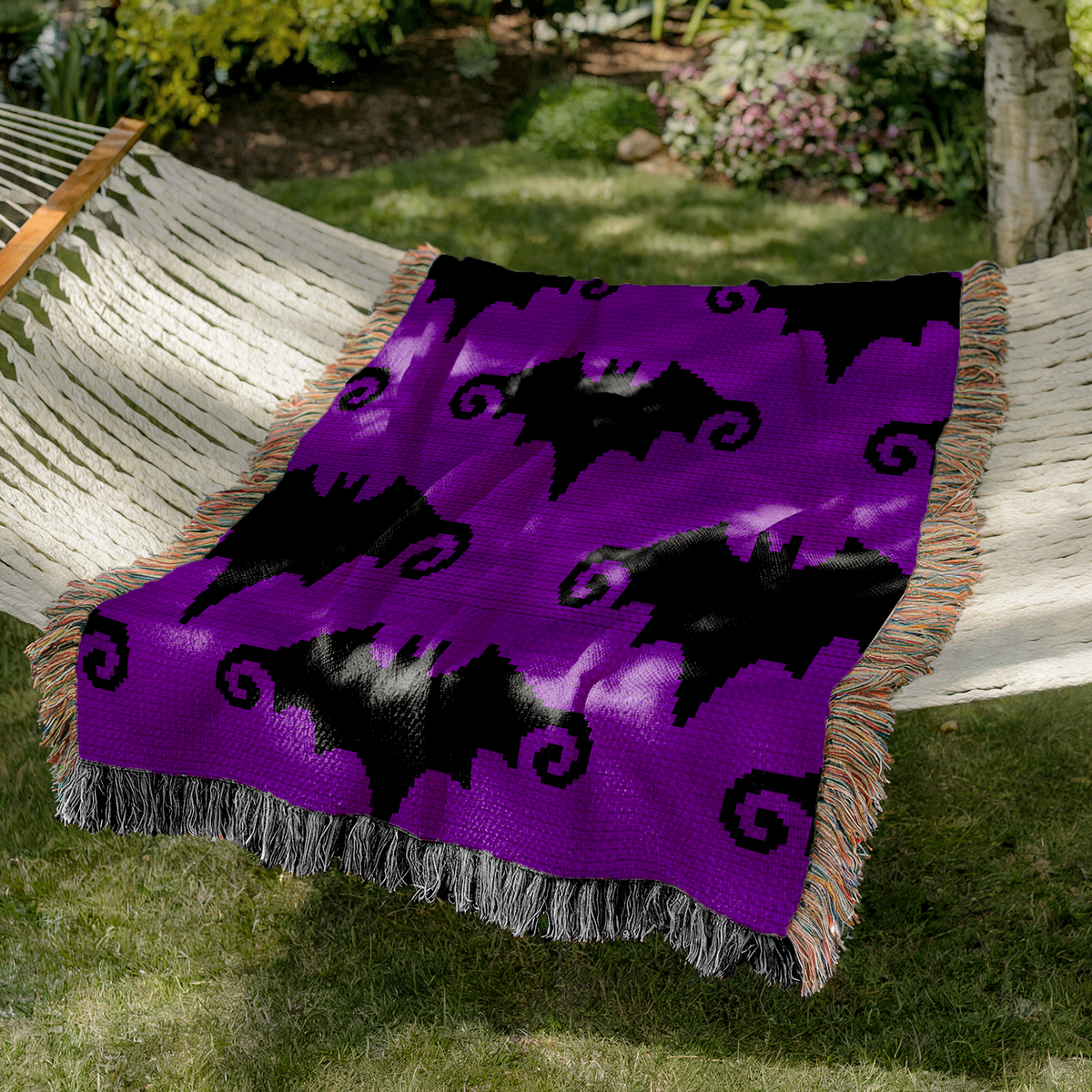 Gothic bat crochet graph pattern with a seamless repeating design in two colors.
Crochet blanket and pillow pattern featuring a bold black bat motif on purple.