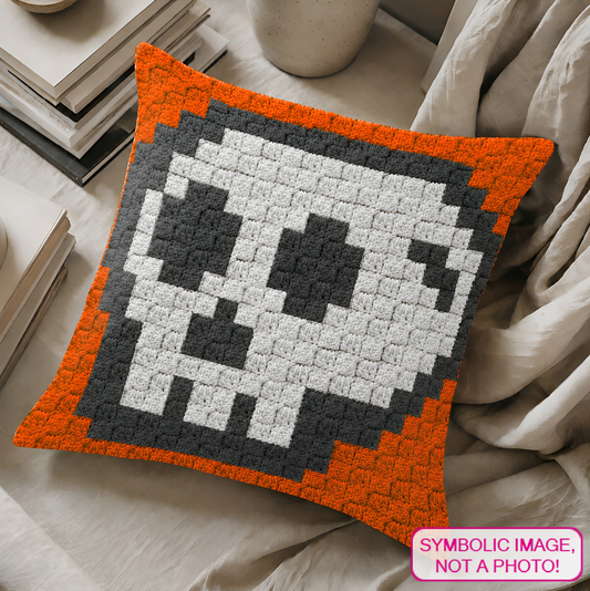 C2C crochet pillow pattern with written instructions featuring a cartoon skull graph design for Halloween and gothic home decor.