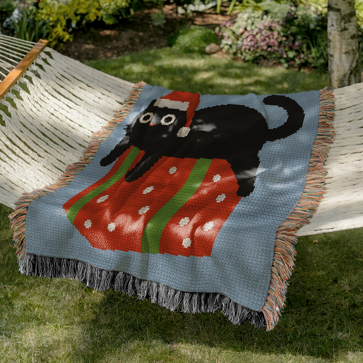 Black cat Christmas crochet blanket pattern shown on a cozy outdoor hammock