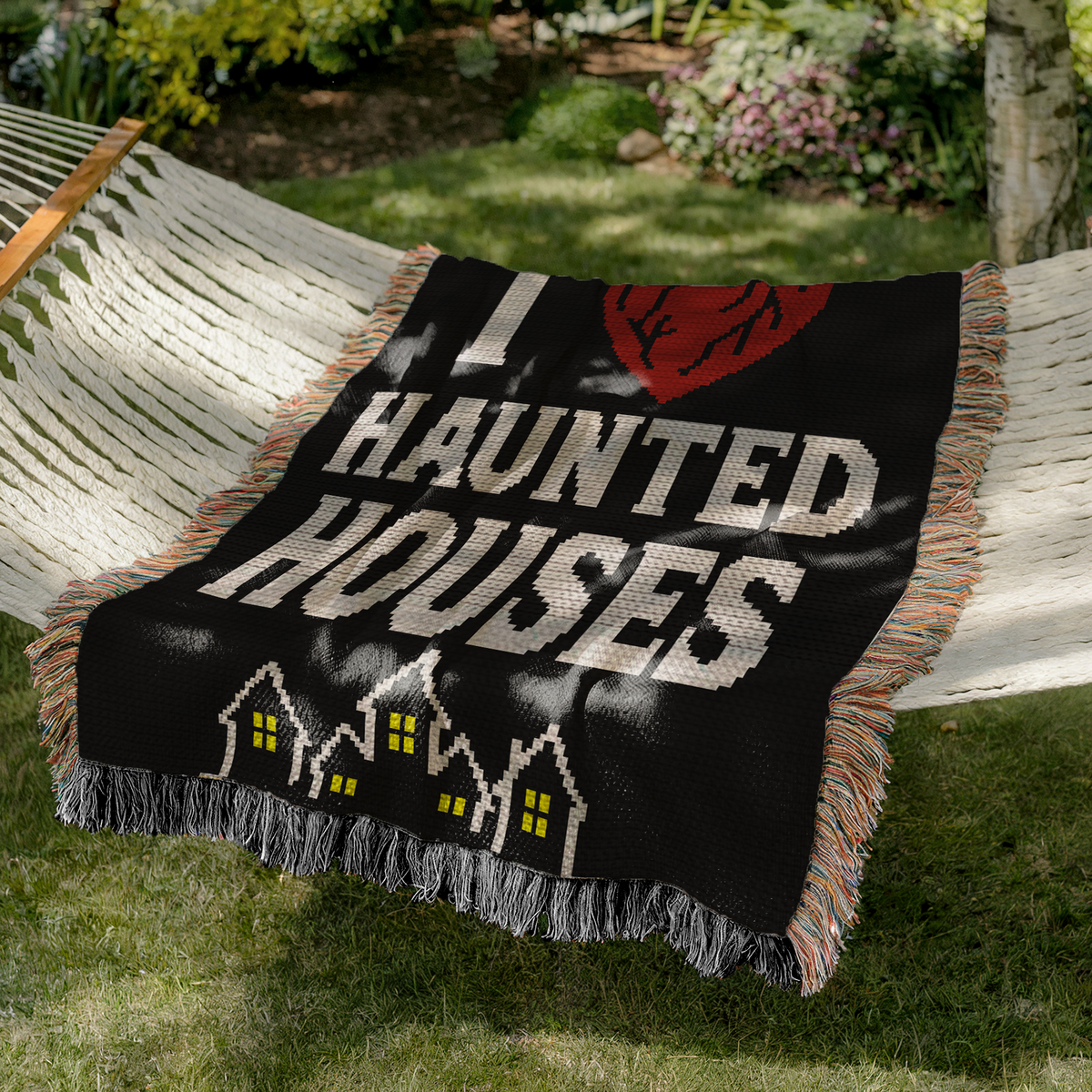 I Heart Haunted Houses SC crochet blanket pattern shown on a black blanket in a garden hammock.