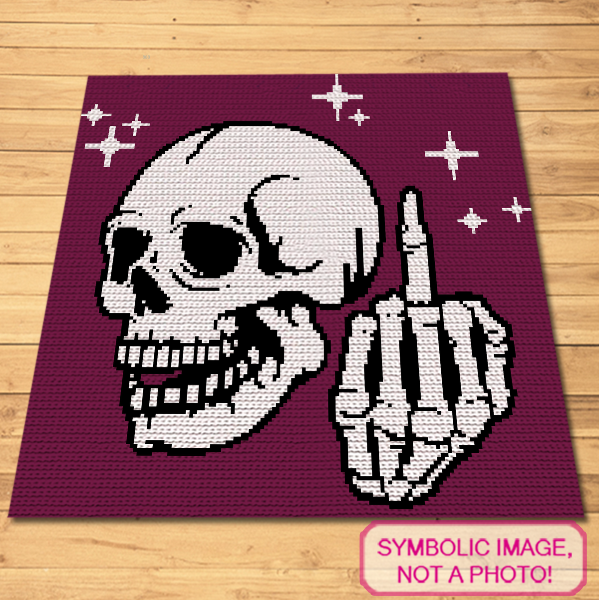 Symbolic flat lay image of the Middle Finger Skeleton crochet blanket on a wooden floor