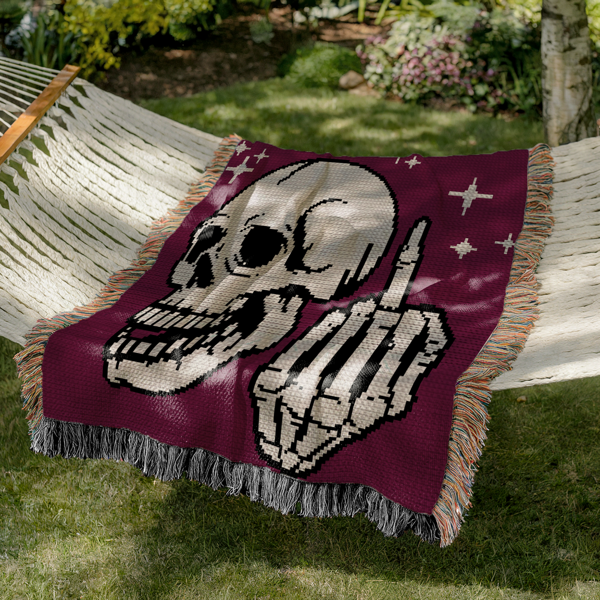 Middle Finger Skeleton crochet blanket draped over a hammock outdoors in a garden