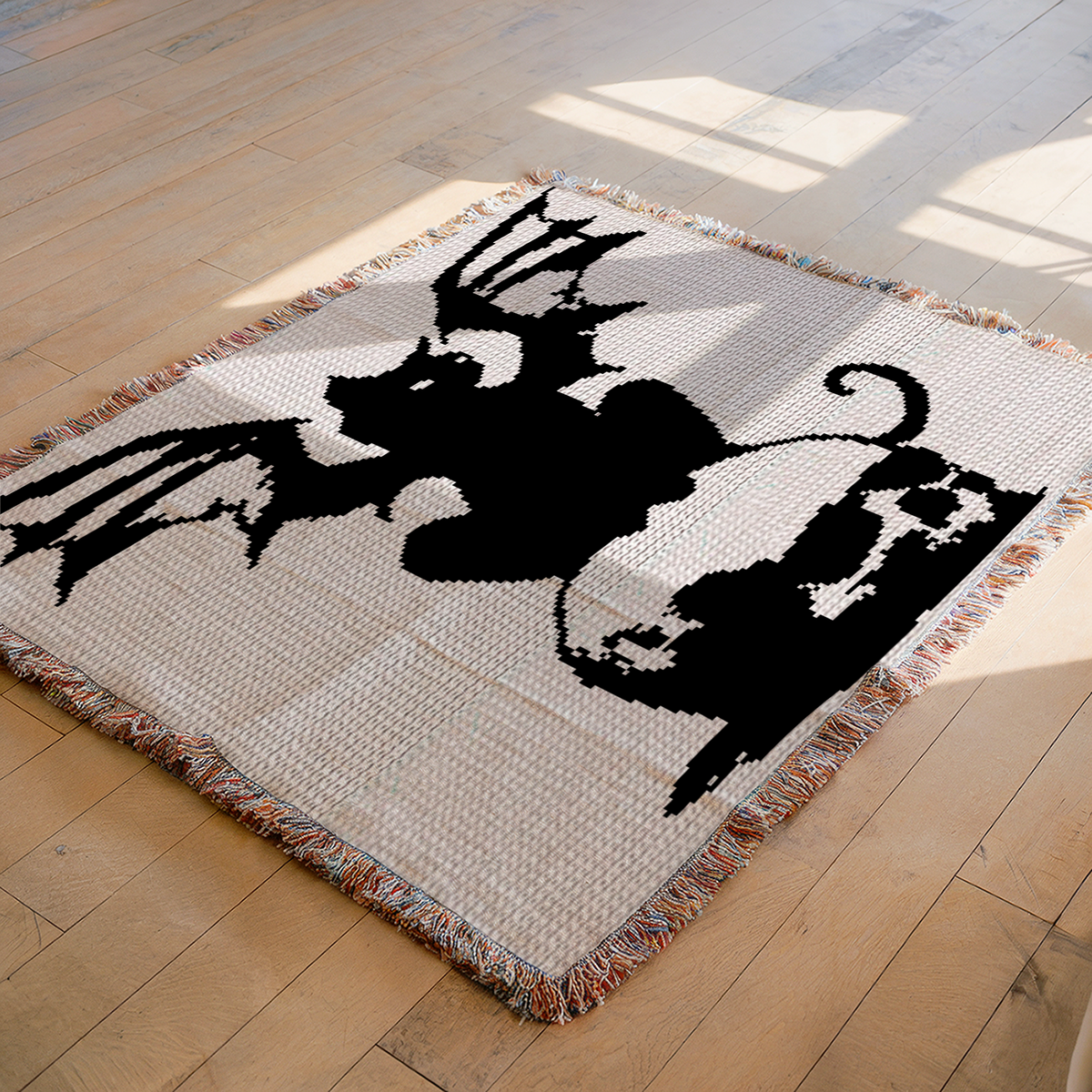 Black winged cat and skull SC crochet blanket pattern displayed on a floor with fringe edging