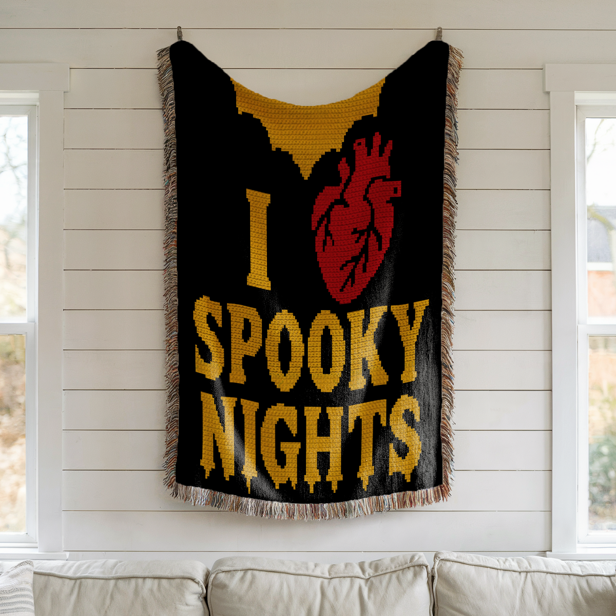 Spooky Nights Halloween crochet blanket displayed on a wall in black yellow and red
