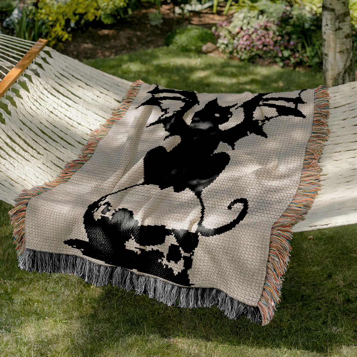 Gothic black cat with bat wings crochet blanket pattern styled in an outdoor hammock
